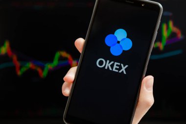 Ukrayna, Odessa - Ekim, 9, 2021: OKEx mobil uygulaması arka planda ticari şamdan şeması ile akıllı telefon ekranında çalışıyor. OKEx kripto döviz ve ticaret platformudur