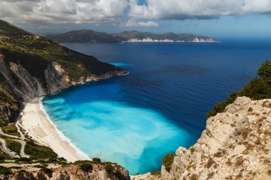 Myrtos Sahili 'nin üst manzarası ve muhteşem turkuaz ve mavi İyon Denizi suyu. Gökyüzü manzarası, ünlü ve son derece popüler Cephalonia, Yunanistan ve Avrupa 'daki yaz manzarası.