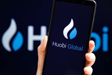 Ukrayna, Odessa - 9 Ekim 2021: Huobi Global mobil uygulaması arka planda Huobi logosu ile akıllı telefon ekranında çalışıyor. Huobi Global kripto döviz ve ticaret platformu..