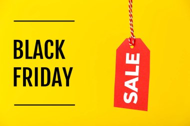 Kara Cuma indirimli fiyat etiketi sarı arka planda izole edilmiş. Alışveriş, satış, indirim konsepti