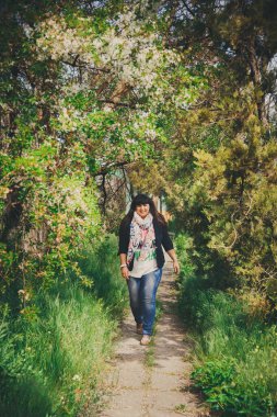 Açık havada çapası olan koyu mavi ceketli ve atkılı güzel, şişman, mutlu bir kadın. Kendine güvenen şişman genç kadın. XXI kadın, artı doğadaki boy kadın.
