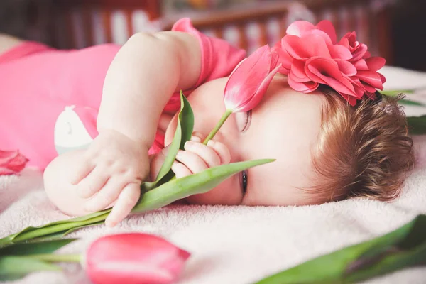 Close Portrait Cute Winking Baby Girl Lying Pink Bed Tulip — Stock Photo, Image