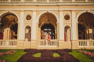 ODESSA, UKRAINE - 15 Ekim 2014: Odessa Operası 'nın balkonunda oturan mutlu çift. İnsan, çok uzak bir yeri parmağıyla işaret ediyor..