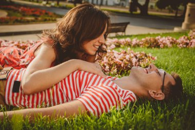 Aşk hikayesi, yeşil çimenlerde uzanan genç kız ve erkek, parkta kucaklaşmak ve birlikte zaman geçirmek..