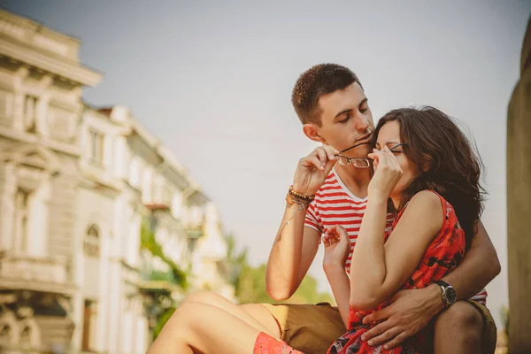 愛の抱擁でかわいい若い笑顔のカップルは 緑の街 夏に屋外に座っている 男は眼鏡をかけている彼のガールフレンドに — ストック写真