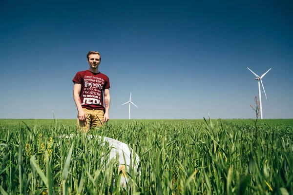 ODESSA, UKRAINE - 20 Mayıs 2015: Eski sörf tahtasıyla genç hippi sörfçü sahile gidiyor, denize bakıyor.