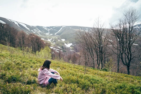 Toeristisch Meisje Roze Regenjas Zittend Het Gras Kijkend Naar Bergen — Stockfoto