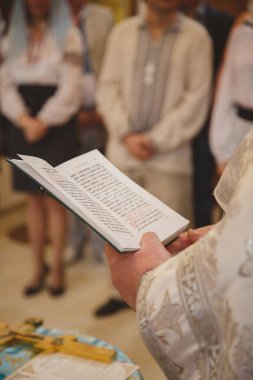 Kilisede vaftiz, rahip İncil 'den bir dua okuyor. Ortodoks Hıristiyan kilisesinde detaylar.