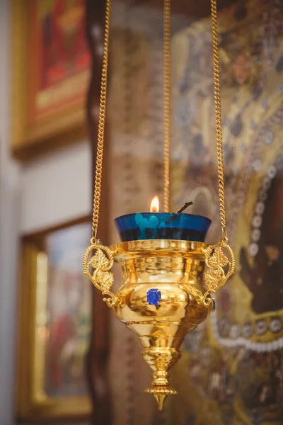 Burning blue and gold icon-lamp, candle in church on a icon background. Details in the orthodox christian church.