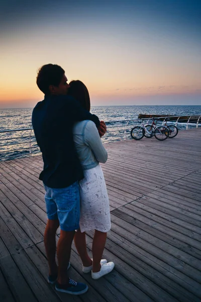 Hugging Couple Looking Sunrise Sky Beach Wooden Deck Summer Time — Stok Foto