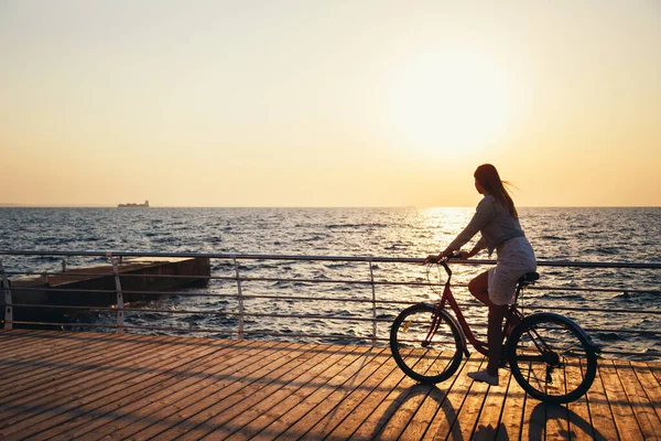 Young Woman Cycling Beach Sunrise Sky Wooden Deck Summer Time — стоковое фото