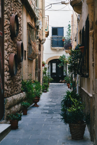 Beautiful view of narrow medieval street in Mdina, ancient capital of Malta, fortified medieval town. Popular touristic destination and attraction.