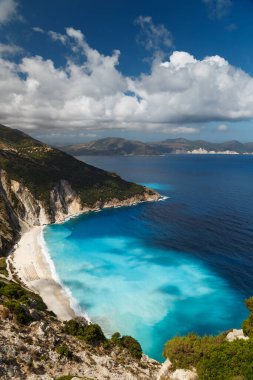 Myrtos Sahili 'nin üst manzarası ve muhteşem turkuaz ve mavi İyon Denizi suyu. Gökyüzü manzarası, ünlü ve son derece popüler Cephalonia, Yunanistan ve Avrupa 'daki yaz manzarası