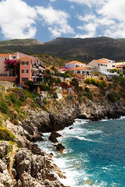 A view at coast of Asos village, Assos peninsula and fantastic turquoise and blue Ionian Sea water. Summer scenery of famous and extremely popular travel destination in Cephalonia, Greece, Europe