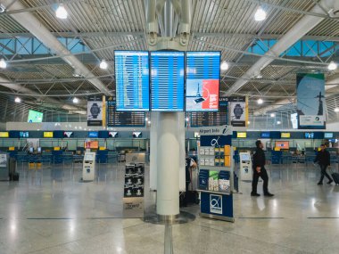 Athens, Greece - February, 11 2020: Athens International Airport Eleftherios Venizelos, Greece. Passengers in the departure hall of the empty main terminal and the departure display in the middle.