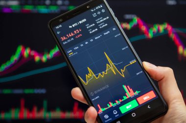 Ukraine, Odessa - June, 1 2021: Trading pair BTC BUSD at Binance mobile app running at smartphone screen with trading page at background. Cryptocurrency exchange and trading platform.
