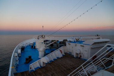 Bow of a passenger cruise ship moving in the open sea. View from the top, port side of the ship