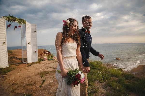 Happy Newlyweds Walk Wedding Altar Sea Shore Confetti — Fotografia de Stock