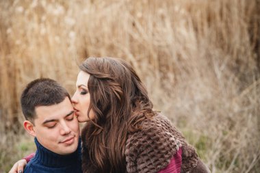 Romantik, çekici, genç çiftin açık havada sarılıp öpüşmesi..