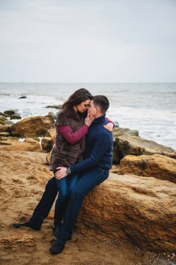 Sahilde kucaklaşan romantik ve çekici genç bir çift..