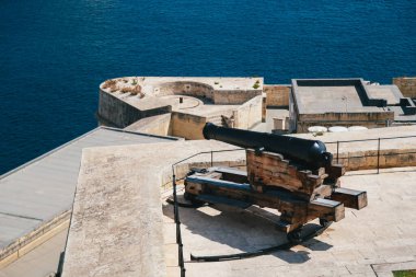A gun, a cannon from Saluting Battery in Upper Barrakka Gardens in Valletta, Malta with a commanding view of Grand Harbor. For almost 500 years, its guns protected the harbor against naval assault.