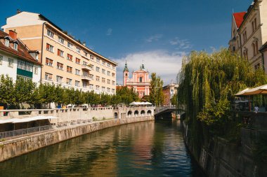 Ljubljana, Slovenia - September, 8 2018: View at river Ljubljanica, Franciscan Church of Annunciation, Cankarjevo Nabrezje and Triple bridge, tourist centre of Ljubljana, capital of Slovenia.