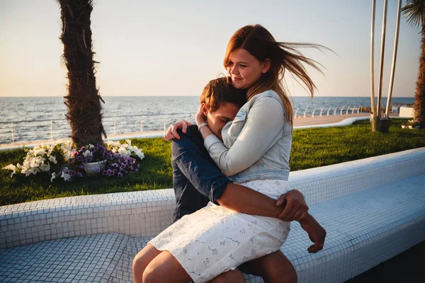 Şirin, genç ve güzel bir çift deniz kenarında oturup birbirlerine sarılıyorlar..