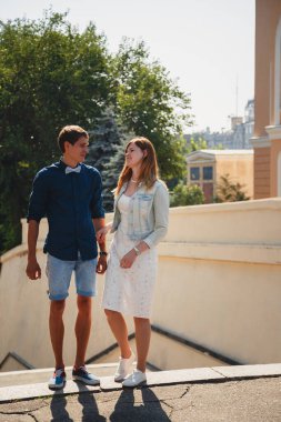 Happy stylish loving couple is talking at the street, outdoors summer time.