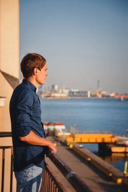 Close up of young stylish guy, man at pier enjoying freedom, happy outdoor portrait.