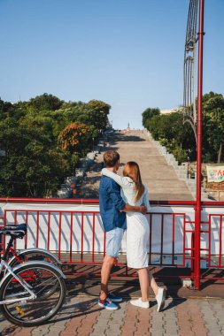 ODESSA, UKRAINE - AUGUST 06, 2015: cute young beautiful hipster couple travel with map, with Potemkin Stairs at background, happy outdoor portrait.