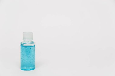 Alcohol sanitizing gel blue color in small bottle on the white background. Small bottle of shampoo or shower gel. Coronavirus personal protective equipment. PPE concept in 2021.
