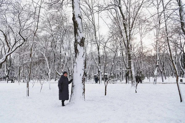 Aged Smiling Woman Standing Big Tree Snow Covered Winter Park — Zdjęcie stockowe