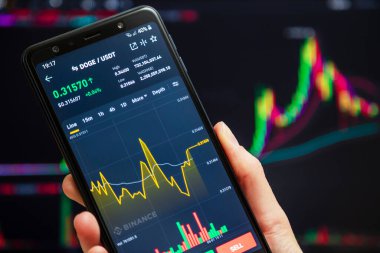 Ukraine, Odessa - June, 1 2021: Trading pair DOGE USDT at Binance mobile app running at smartphone screen with a trading page at background. Binance is cryptocurrency exchange and trading platform