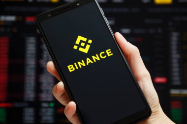 Ukraine, Odessa - June, 1 2021: Binance mobile app running at smartphone screen with a trading page at background. Binance one of the world's leading cryptocurrency exchange and trading platform.