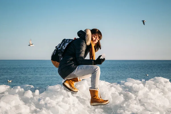 Young Smiling Woman Sitting Top Sea Ice Blocks Coast Holding — Stock fotografie