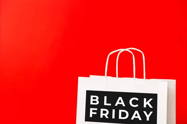Black Friday white paper bag isolated on red background. Black friday sale, discount, shopping concept