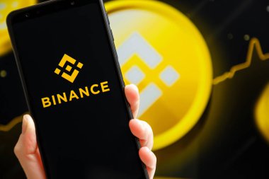 Ukrayna, Odessa - 9 Ekim 2021: Binance mobil uygulaması arkaplanda Binance logosu olan akıllı telefon ekranında çalışıyor. Binance dünyanın önde gelen kripto döviz ve ticaret platformlarından biri.