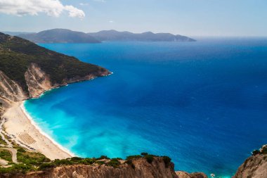 Myrtos Sahili 'nin üst manzarası ve muhteşem turkuaz ve mavi İyon Denizi suyu. Gökyüzü manzarası, ünlü ve son derece popüler Cephalonia, Yunanistan ve Avrupa 'daki yaz manzarası.