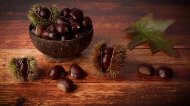 Herbst Kastanien Auf Einem Rustikalen Holztisch Mit Einem Herbstblatt Hintergrund — Stockvideo