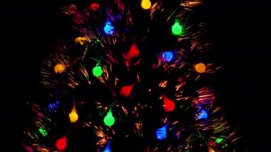 Çok renkli ve yanıp sönen ışıklar Noel ağacını gece aydınlatır. Noel konsepti. Sürgülü fotoğraf..