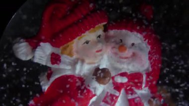 Noel zamanı. Sevimli çocuk kardan adama sarılıyor. Noel süslemesi..