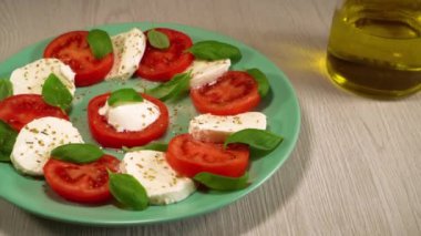 İtalyan Caprese salatası. Sulu taze domates, kremalı mozzarella, taze fesleğen ve ekstra saf zeytinyağı. Sağlıklı yemek. Biyolojik yemek, organik gıda.