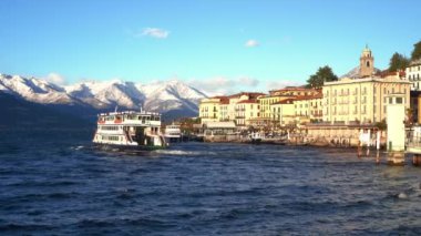 Bellagio, kışın gün batımında Como Gölü 'nün incisi. Arka planda İtalyan Alpleri ile Como Gölü' nü geçen feribot. İtalya 'ya git