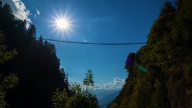 Zaman aşımı - İtalya 'nın en yüksek Tibet Köprüsü' nde güneşli bir günde yürüyen insanların silueti. Panoramik manzara Ponte nel cielo, Sky bridge - Val Tartano, Sondrio Italy.Valtellina