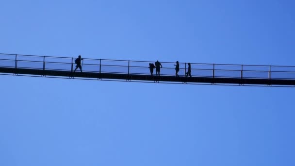イタリアアルプスのヨーロッパで最も高いチベット橋を歩く人々のシルエット4KponteチャンネルCielo 空の橋 Valtartano Sondrio Italy Valtelina — ストック動画