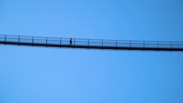 イタリアアルプスのヨーロッパで最も高いチベット橋を歩く女性のシルエット 4Kponte Nel Cielo Bridge Sky Val Tartano Sondrio Italy — ストック動画