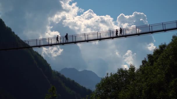 イタリアアルプスのヨーロッパで最も高いチベット橋を歩く人々のシルエット4KponteチャンネルCielo 空の橋 Valtartano Sondrio Italy Valtelina — ストック動画