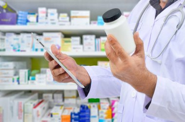 Eczacının elinde eczane raflarında arama çubuğu için kapsül paketi ve dokunmatik ped var. Çevrimiçi tıbbi konsept