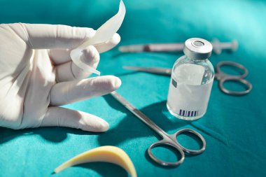 Ameliyat odasında silikon burun implantı ve cerrahi ekipman ve ilaç şişesi var..