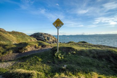 Patikadaki uyarı levhası Howth Head, Dublin, Dublin County, Sahil şeridi, uçurumlar, koylar ve kayalıklar manzarası.
